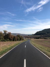 Empty road along countryside landscape