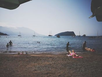 People on beach against sky