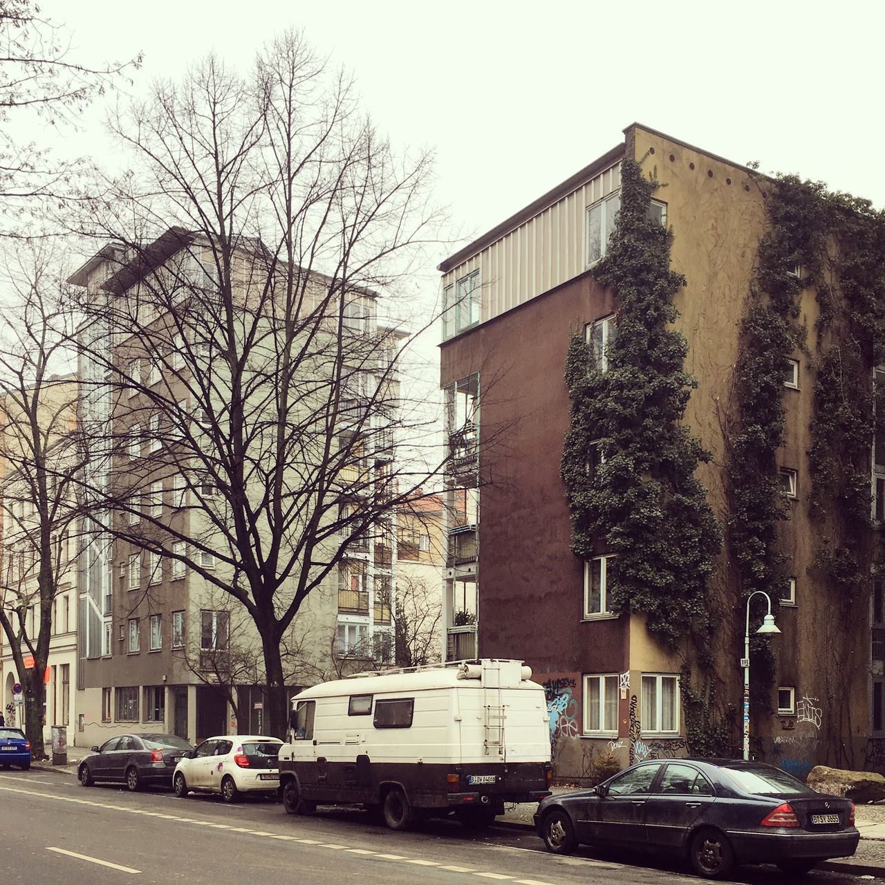 CARS ON ROAD AGAINST BUILDINGS