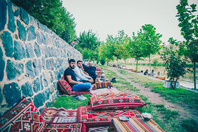 People sitting at park against sky