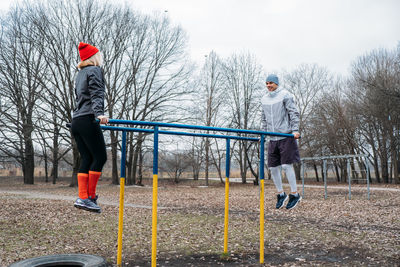 Side view of two people on parallel bar