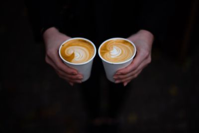 Midsection of woman holding coffee cups