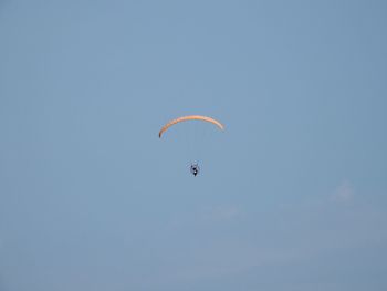 Low angle view of person paragliding against clear sky