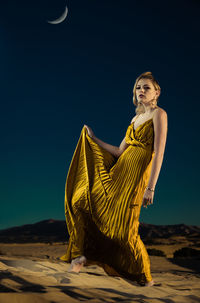 Portrait of young woman against sky