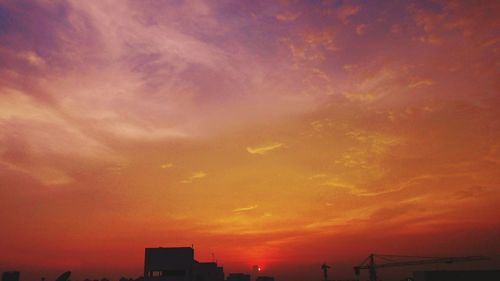 Silhouette of city against sky during sunset