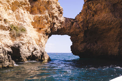 Scenic view of rock formation in sea against sky