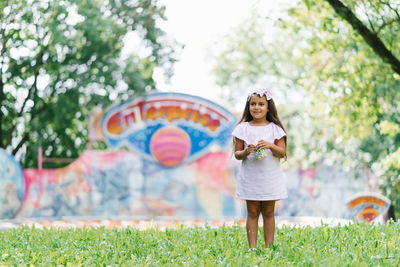 Cute little girl in the summer in the park holding popcorn in her hands