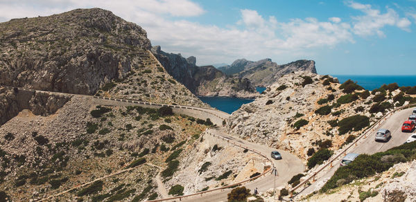 Scenic view of sea by mountains against sky