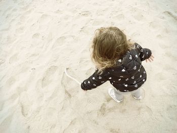 High angle view of girl playing at sandy beach 