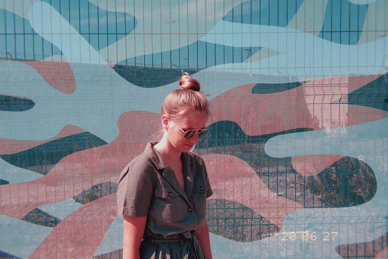 WOMAN STANDING AGAINST WALL