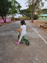 Rear view of boy riding motorcycle on road