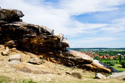 Rock formations by sea against sky