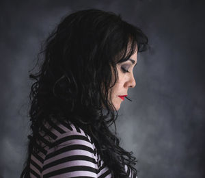 Side view of mature woman looking down against wall