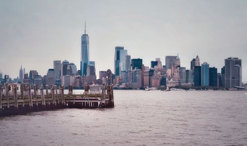 Pier over river with modern buildings at manhattan