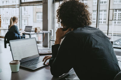 Businessman using laptop while sitting in coworking space