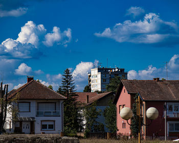 Houses and buildings in town against sky