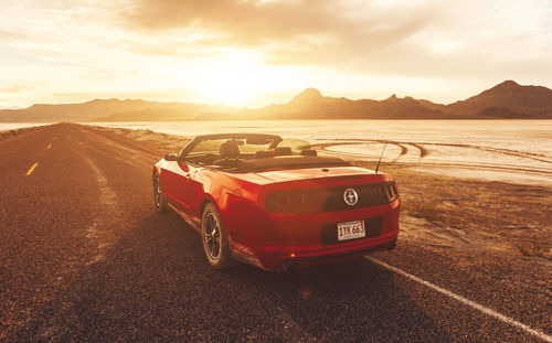 Car on road against sky during sunset