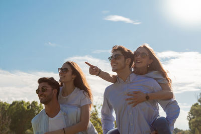 Portrait of young couples standing against sky