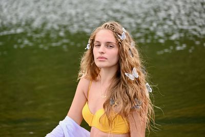 Portrait of beautiful woman against lake