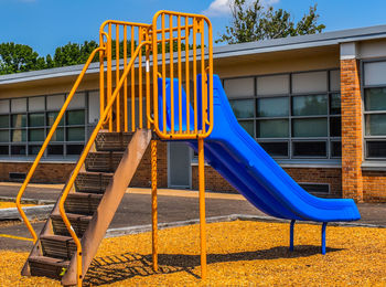 Low angle view of slide in playground against blue sky