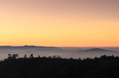 Scenic view of silhouette mountains against sky at sunset