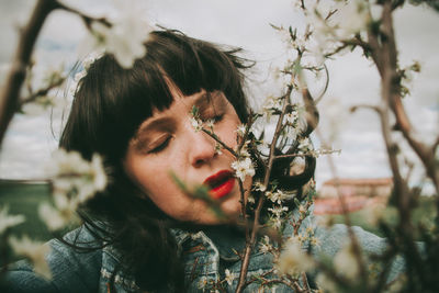 Portrait of woman with red flowering plants