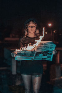 Full length portrait of woman standing at night