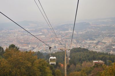 Overhead cable car over mountains against sky