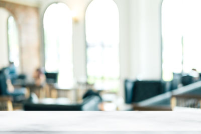 Defocused image of empty chairs and table in building