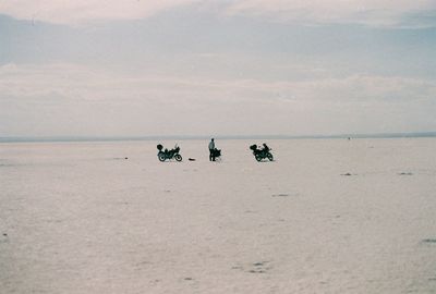 People on beach against sky