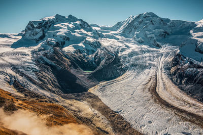 Aerial view of snowcapped mountains against clear sky