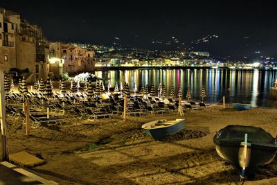 Boats moored on beach against sky at night