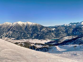 Scenic view of snowcapped mountains against clear blue sky