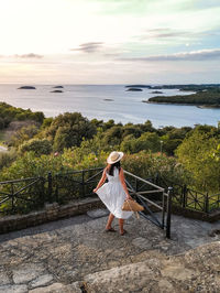 Woman looking at sea against sky