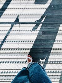 Low section of woman walking on floorboard