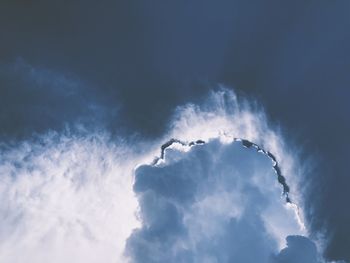 Low angle view of smoke against blue sky