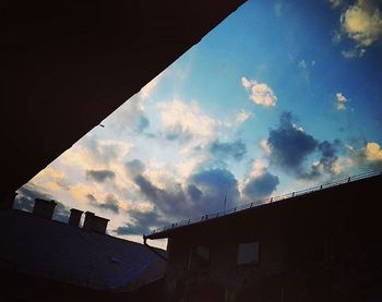 Low angle view of buildings against cloudy sky