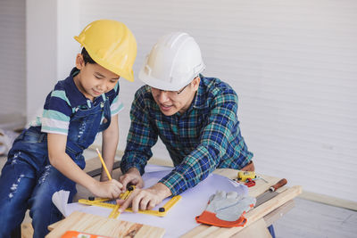 Engineer assisting son in making drawing