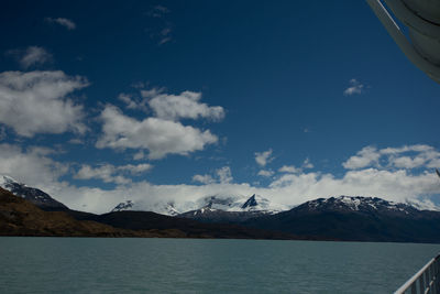 Scenic view of sea by mountains against sky