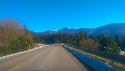 Country road against clear blue sky