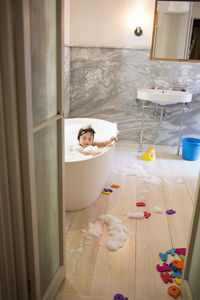 Boy looking away while bathing in bathtub