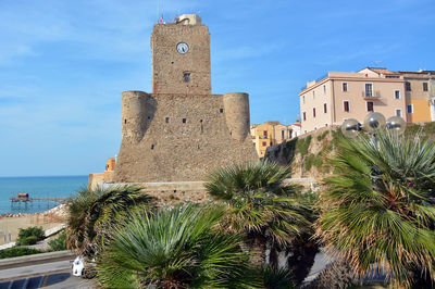 Palm trees and buildings against blue sky