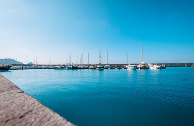 Sailboats in sea against blue sky