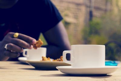 Person eating refreshment at sidewalk caf