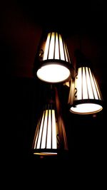 Low angle view of illuminated lamp in darkroom