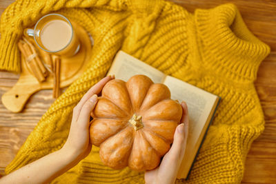 Cropped hand of woman holding pumpkin