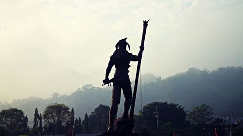 Low angle view of man working against sky