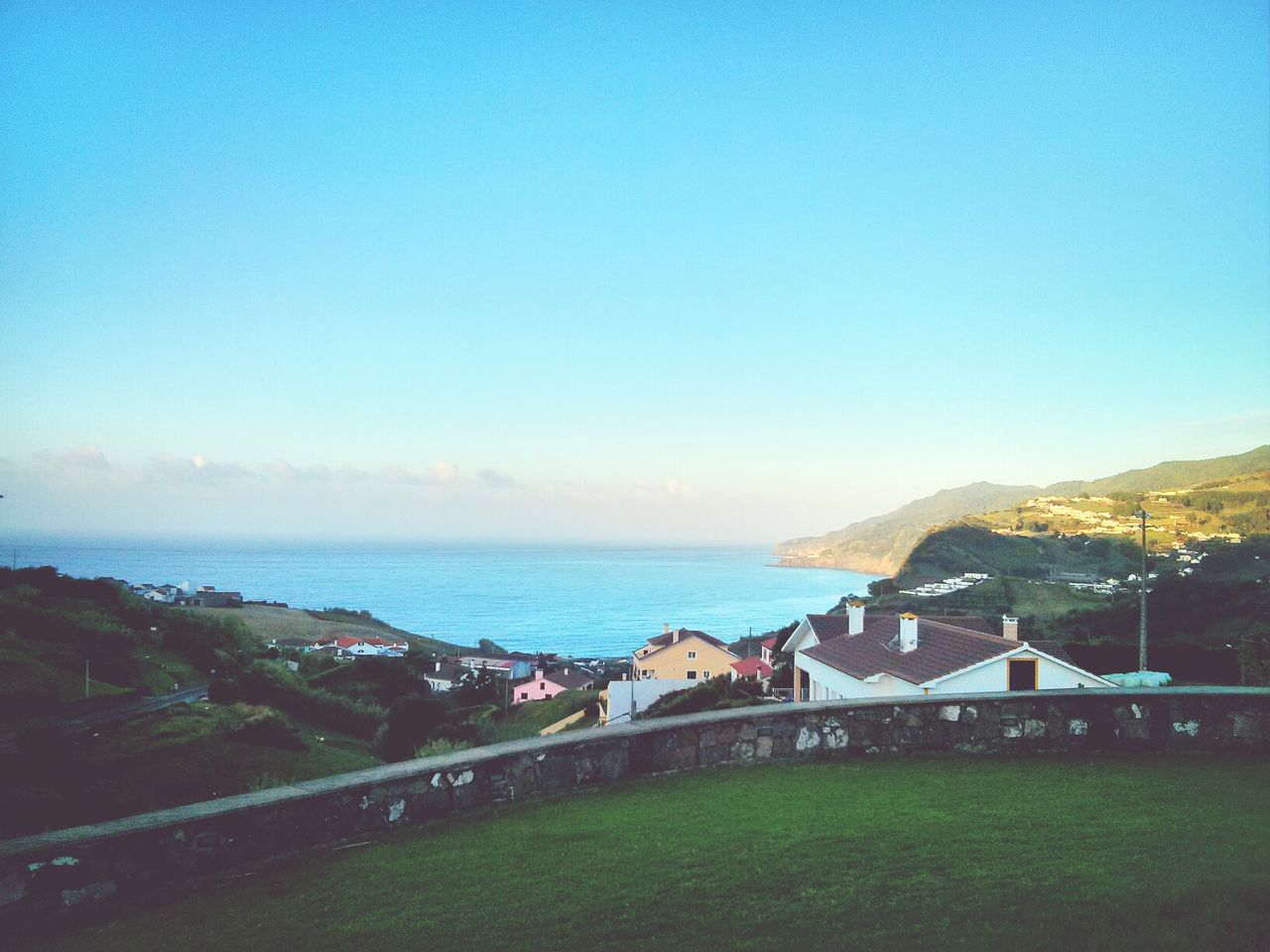 blue, copy space, clear sky, sea, water, horizon over water, built structure, architecture, building exterior, scenics, tranquil scene, nature, beauty in nature, tranquility, high angle view, sky, outdoors, coastline, sunlight, beach