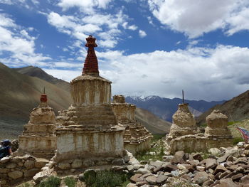 Stupas of building against cloudy sky