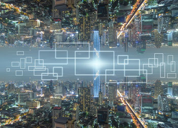 Aerial view of illuminated modern buildings in city at night